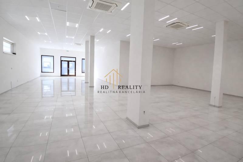 Spacious commercial spaces with white walls and shiny floors.