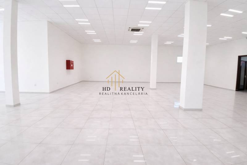 Spacious commercial spaces with white flooring and columns, bright lighting.