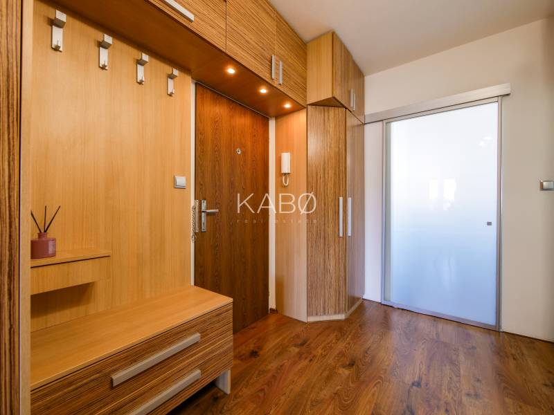 Entrance hallway in a 3-room apartment with wood-patterned flooring and built-in furniture.