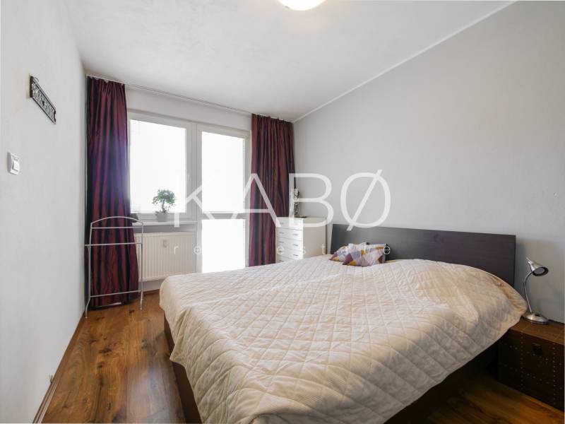 Bedroom in a 3-room apartment with a wooden decor floor and a bed.