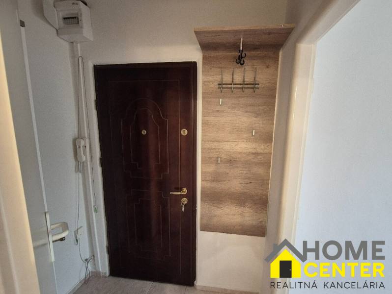Doors with curtains and a coat rack in the hallway of a studio apartment.