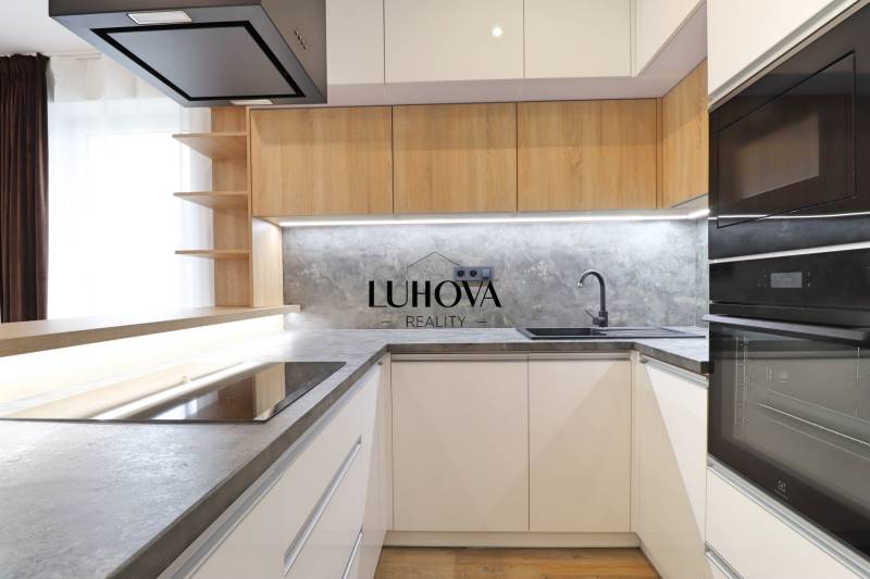 A kitchen with sleek lines and a wooden decor floor in a 3-room apartment.
