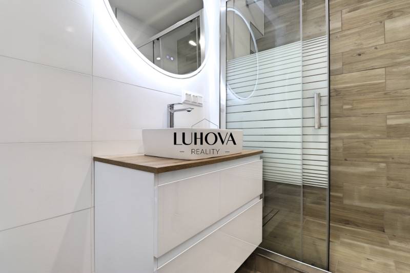Bathroom with a sink and a shower in a 3-room apartment, floor with wooden decor.
