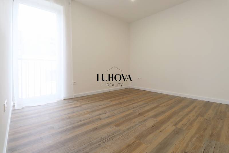 A room in a 3-room apartment with a wooden decor floor and a simple design.