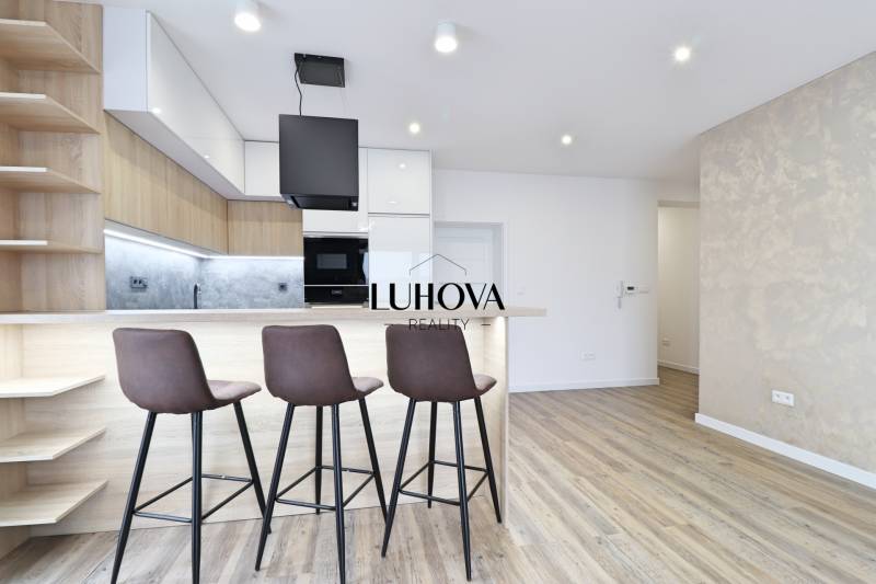A kitchen with a bar counter and a wooden decor floor in a 3-room apartment.