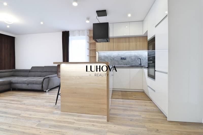 Living room with kitchen and wooden decor flooring in a 3-room apartment.