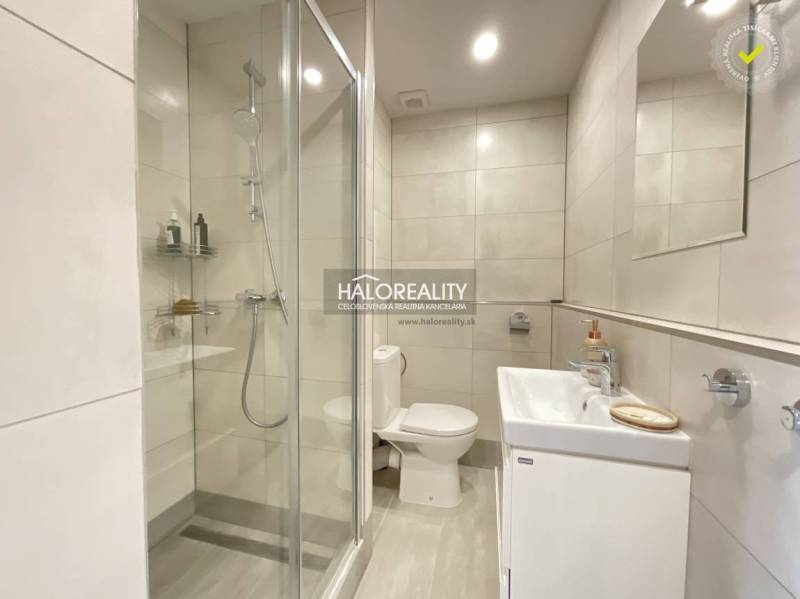 Bathroom in a studio apartment with a bathtub, shower, and sink.
