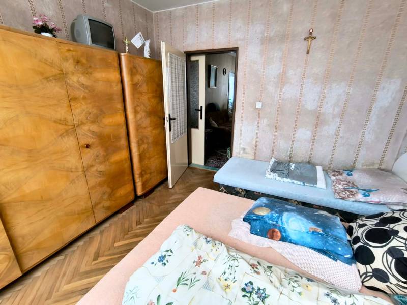 Bedroom in a 3-room apartment with a large wooden wardrobe and a floor with a wooden decor.