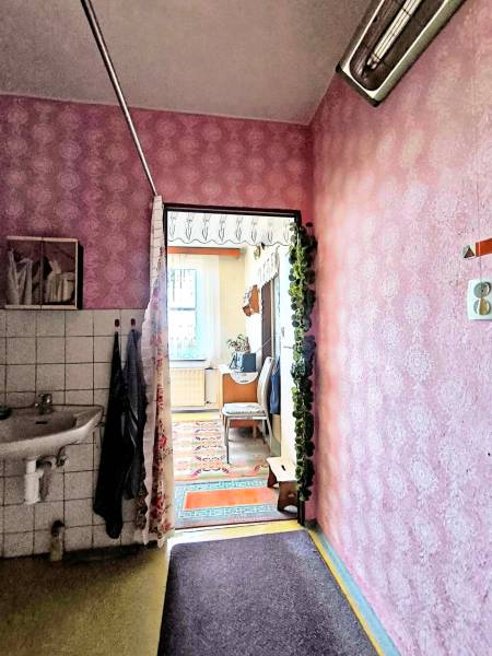 A hallway with pink walls, a sink, and a view into a room, 3-room apartment.