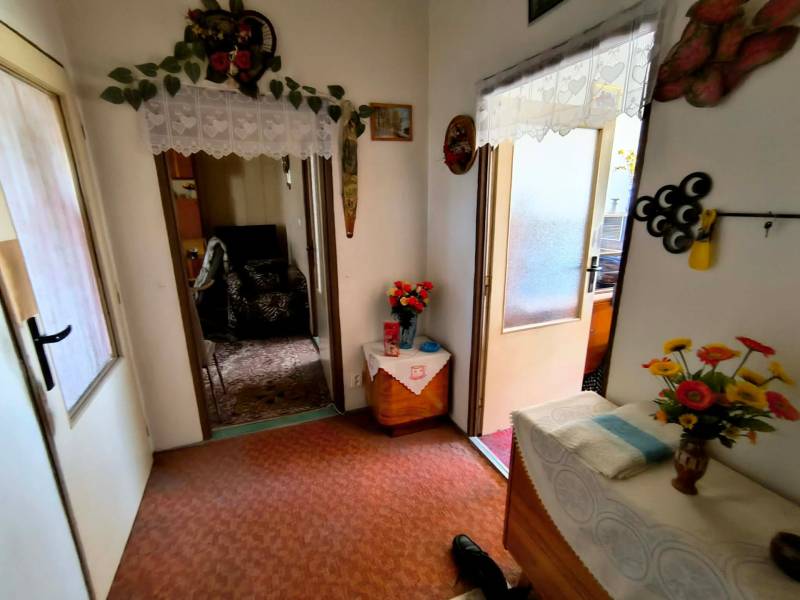 Entrance hall in a 3-room apartment with decorations and flowers on the table.