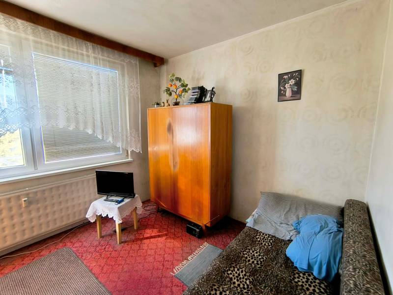 A room in a 3-room apartment with a wardrobe, a sofa, and a small screen.