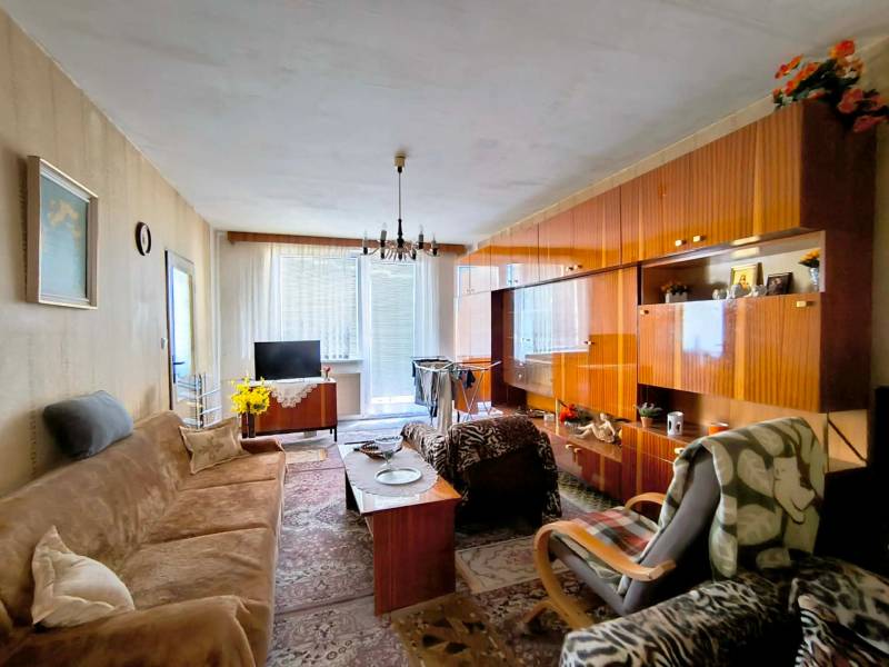 Living room in a 3-room apartment with a wooden decor floor and a sofa set.