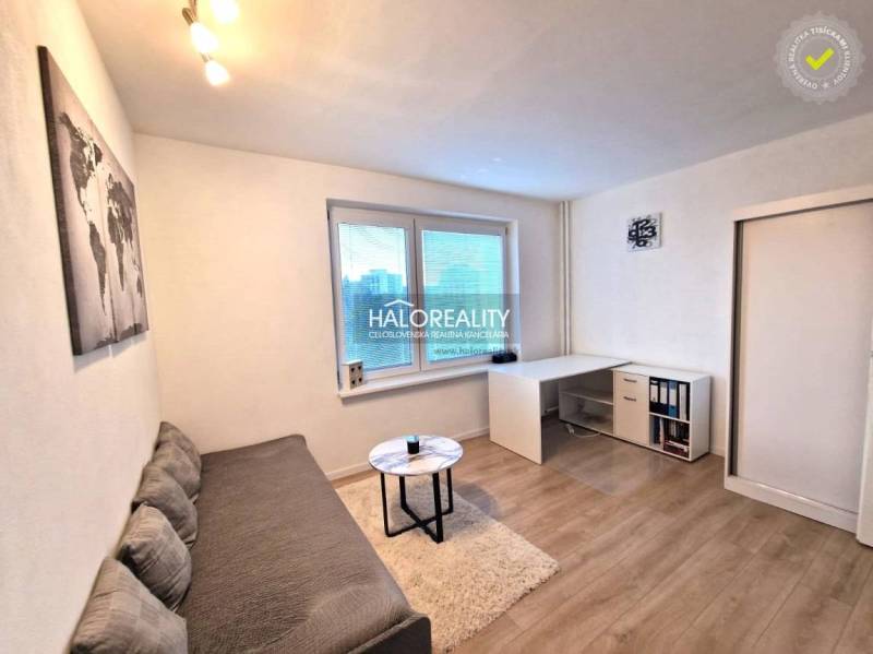 Living room in a 3-room apartment with a sofa, a table, and a wooden decor floor.