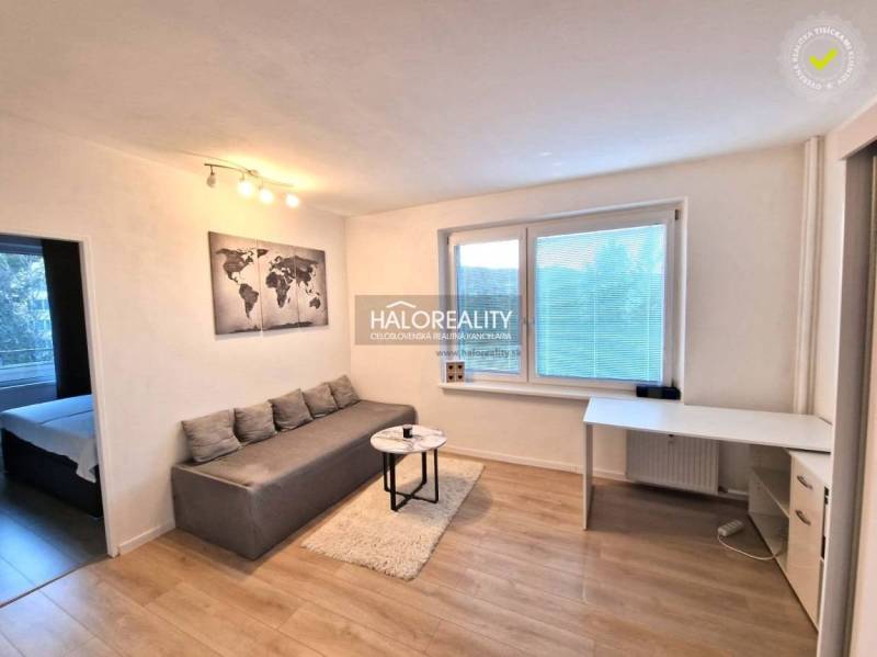 Bright living room in a 3-room apartment with wood-patterned flooring and a dining table.