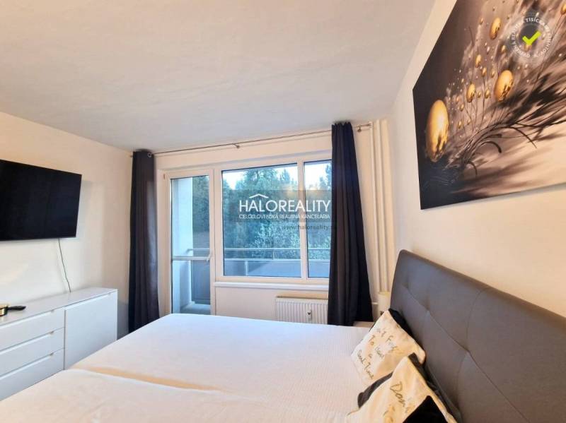 A bedroom in a 3-room apartment with a large bed, a TV, and a balcony.