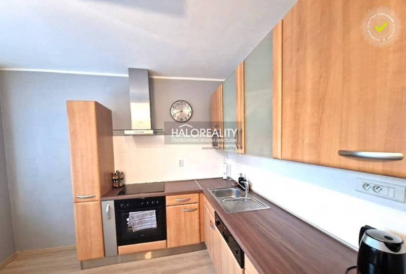 A kitchen in a 3-room apartment with wooden cabinets and silver appliances.