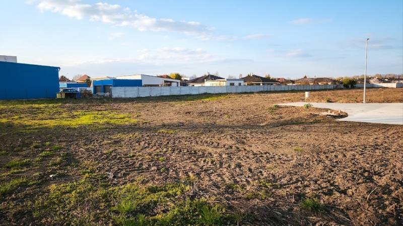 Commercial land in Kráľová nad Váhom with a spacious open area and fenced buildings.