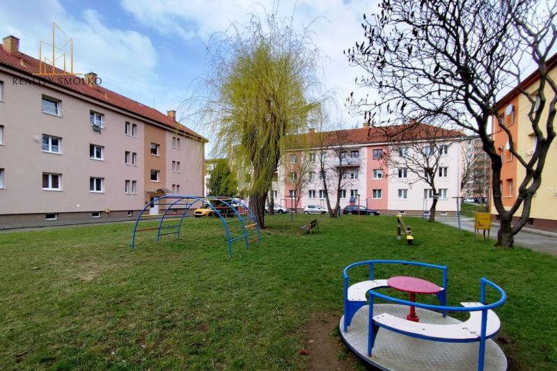 Playground with climbing frames and trees on Mierova Street in Sabinov, in front of a 2-room apartment.