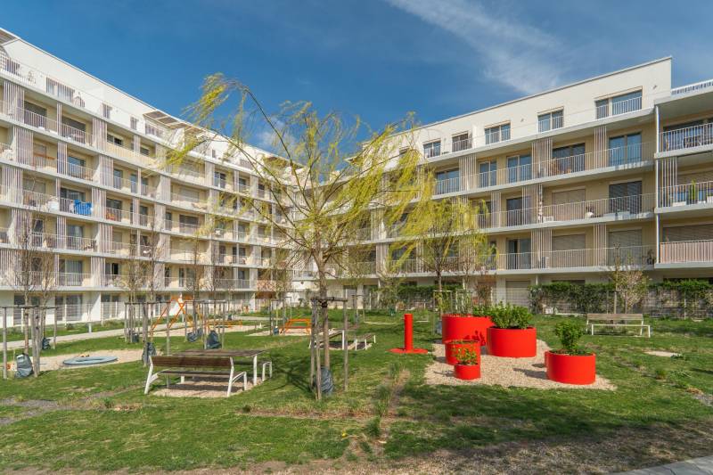 View of a residential building and courtyard with a playground in Bratislava - Ružinov.