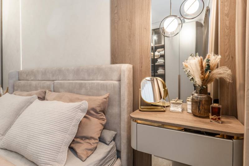 A bedroom in a 3-room apartment with a bed, a mirror, and decorative elements.