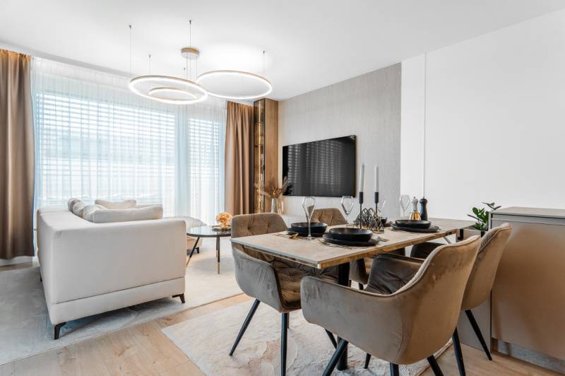 Living area with a dining table and a wooden decor floor in a 3-room apartment.