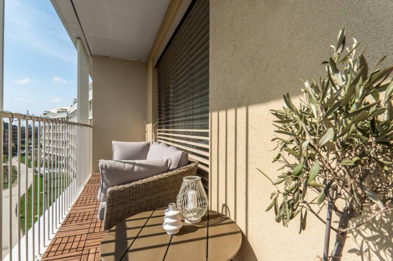Balcony in a 3-room apartment with comfortable seating, view, and decorations.