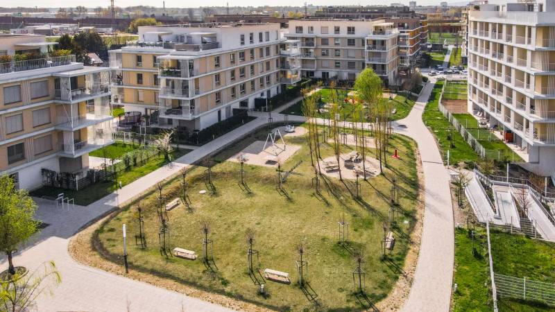 In Bratislava - Ružinov, between apartment buildings, there is a green park with a playground.