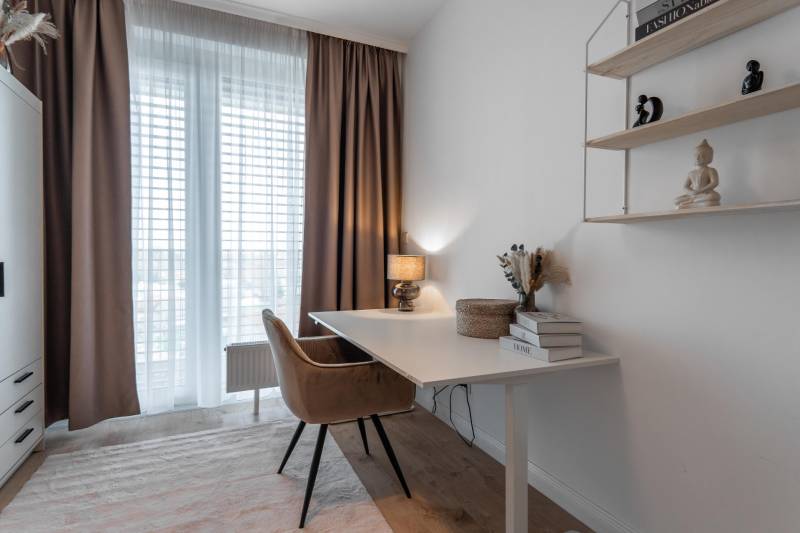 A workspace with a desk, a comfortable chair, and a shelf in a 3-room apartment.