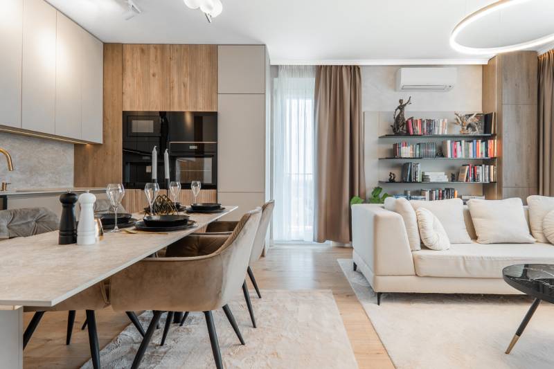 Open-plan three-room apartment with a kitchen, dining table, and comfortable living area.