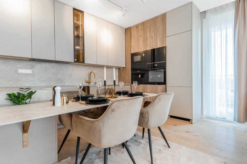 A stylish kitchen in a 3-room apartment with a dining table and a wooden decor floor.