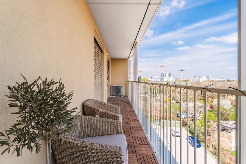 Balcony in a 3-room apartment with a wooden decor floor, view of Bratislava - Ružinov.
