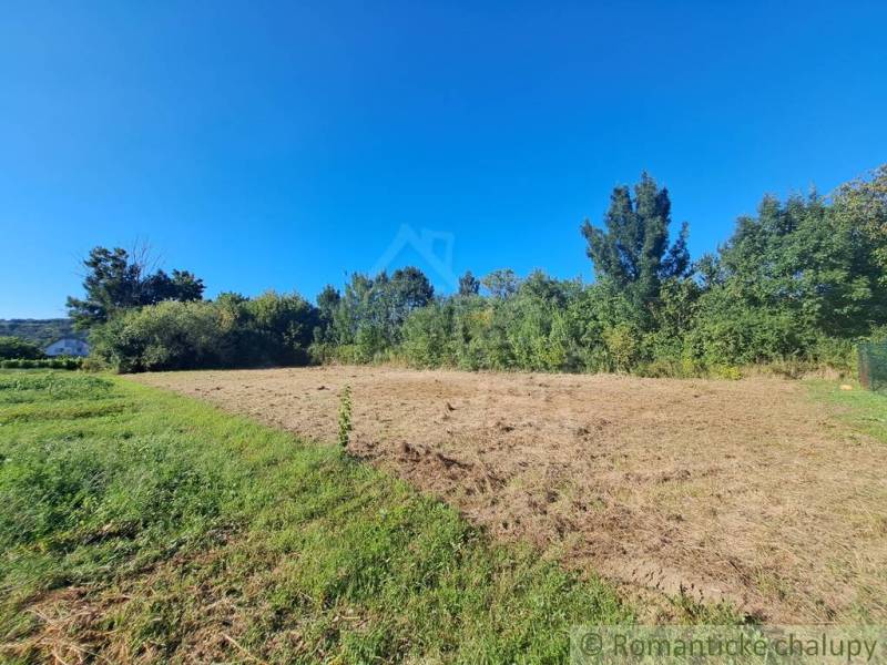 A plot in Hosťová for living, surrounded by greenery and blue skies.