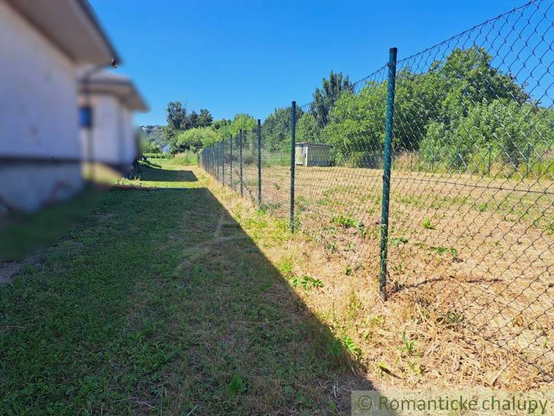 Grassy plot with a fence in Hosťová, ideal for living.