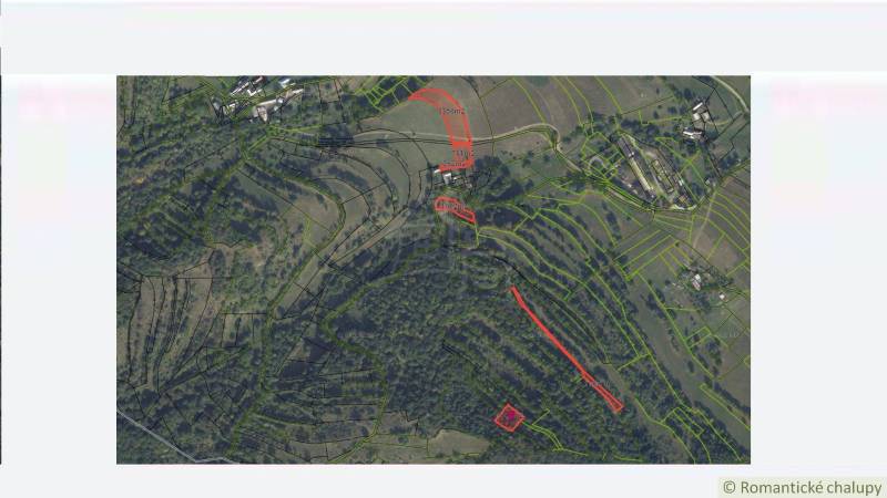 Aerial view of parceled plots for housing in Horný Tisovník with a forested landscape.