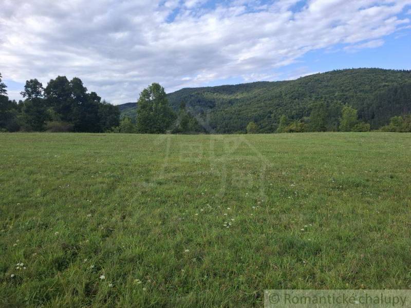 Extensive meadow plots for housing in Horný Tisovník, surrounded by forests and hills.