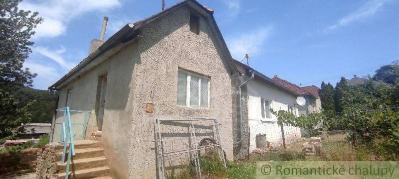 A family house in Šiatorská Bukovinka with stone stairs and a garden, with a blue sky in the background.
