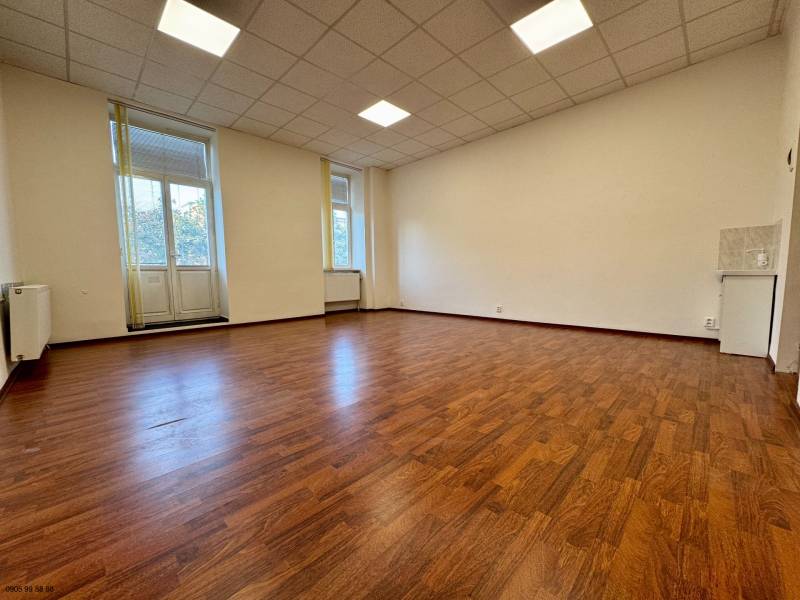 Spacious offices with wood-decor flooring and large windows.
