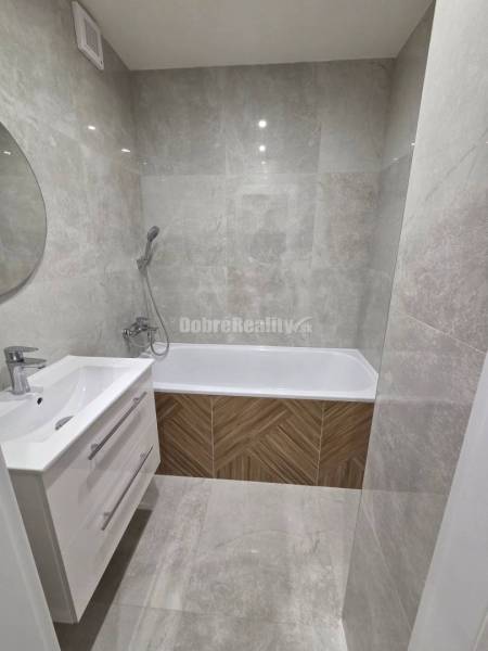 A bathroom with a shower faucet and a bathtub in a 3-room apartment.