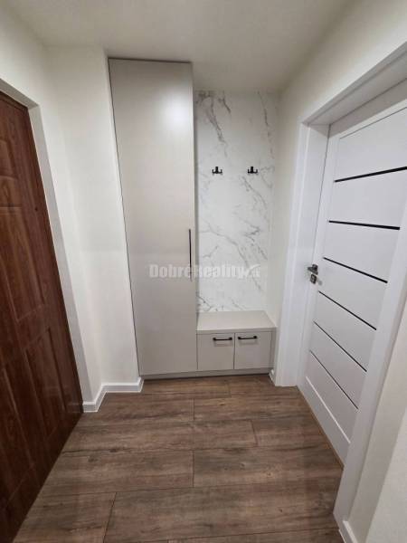 Hallway with a wardrobe and hooks, marble decor, floor with wooden decor.