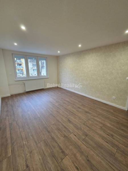 Living room with wood-patterned flooring in a 3-room apartment, light and simplicity.