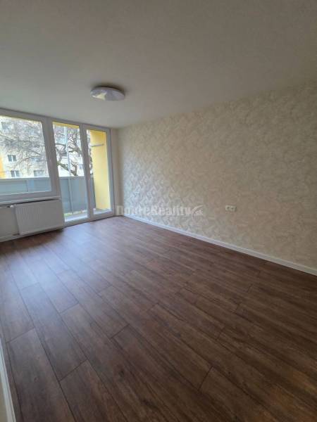 A room with light walls and a floor with a wooden decor in a 3-room apartment.