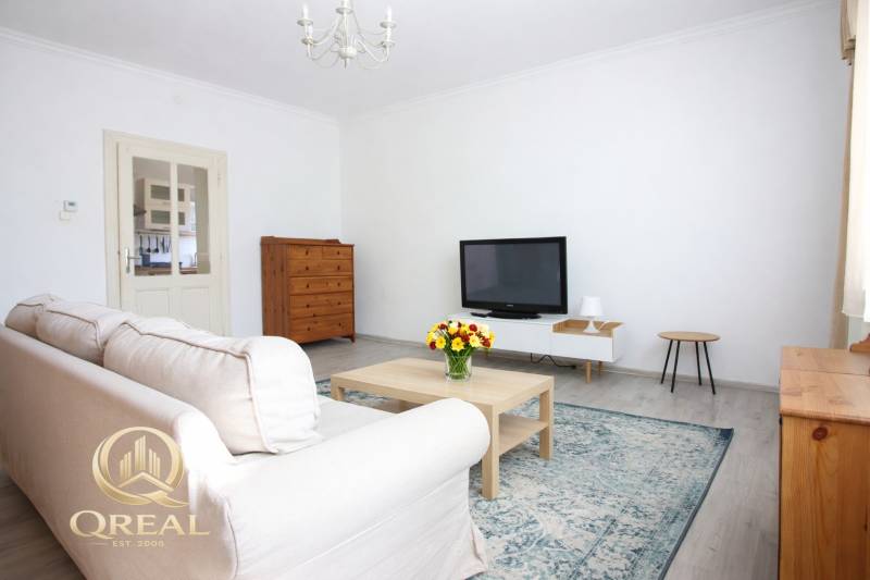 Living room with a TV, sofa, and coffee table in a studio apartment.