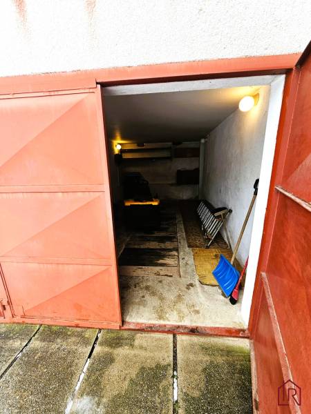 A garage in a family house in Kameňany with open metal doors and tools.