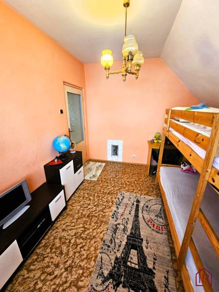 A room in a family house with a bunk bed and a carpet with the Eiffel Tower.