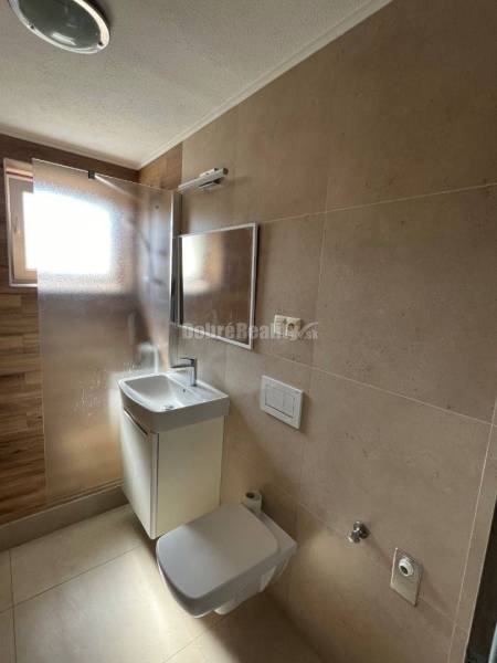 Bathroom in a 2-room apartment with a sink, shower, and toilet.