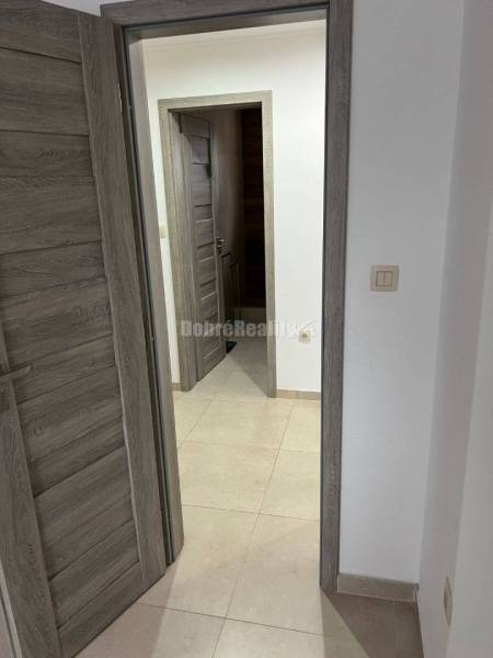 Interior of a 2-room apartment with tiled flooring, wooden decorated doors.