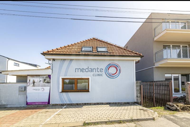 A family house on Podpriehradná in Bratislava-Vrakuňa with an advertisement for a clinic.