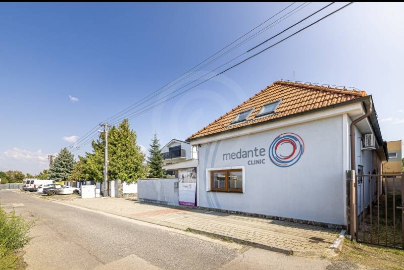 A family house on Podpriehradná Street in Bratislava-Vrakuňa with the clinic's logo.