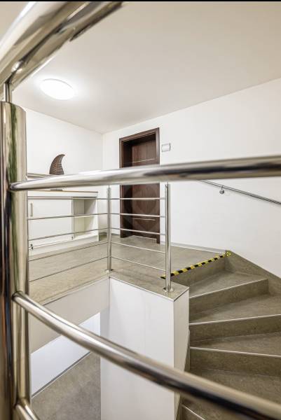 A staircase with a metal railing and neutral walls in a family house.