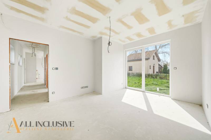 A bright room in a cottage with large windows and a view of the garden.